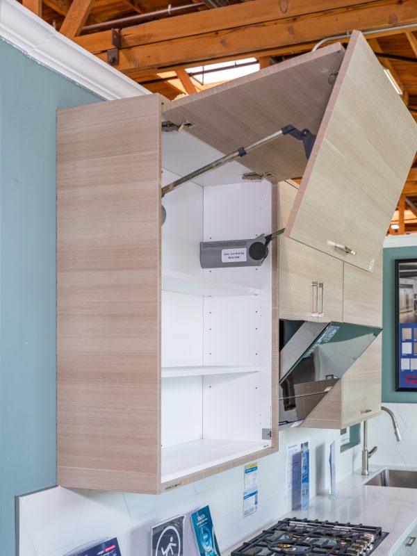 Two wooden cabinet doors open showing white interior shelves and 'Exc-Lift System Electric' hardware mechanism mounted inside