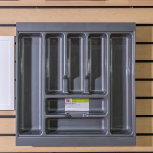 Gray plastic drawer organizer with compartments displayed on wooden shelf next to wood samples labeled M31 and M17