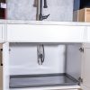 Under-sink cabinet interior with gray pull-out storage tray and plumbing connections visible