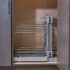 Interior view of kitchen cabinet with extended pull-out wire basket storage system displaying three-tier chrome shelving for corner cabinet organization
