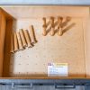 Open kitchen drawer displaying wooden peg board organizer with rolling pins and utensils