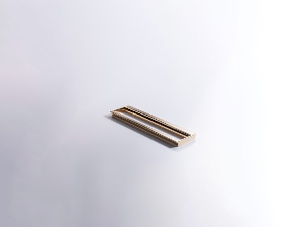 Gold and black metal flush-mount handle with sleek modern style on white surface