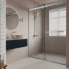 Modern bathroom interior with beige walls, white subway tile accent, sliding glass shower enclosure, round mirror, black vanity cabinet, and window with blinds