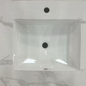 White rectangular ceramic vessel sink with overflow hole and single faucet hole, mounted on marble countertop