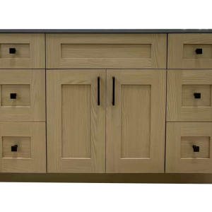 Natural oak wood vanity with dark countertop, six drawers on sides, and two center cabinet doors with black handles